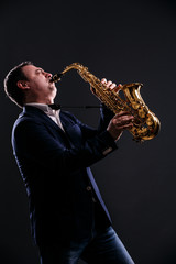 musician plays jazz at saxophone