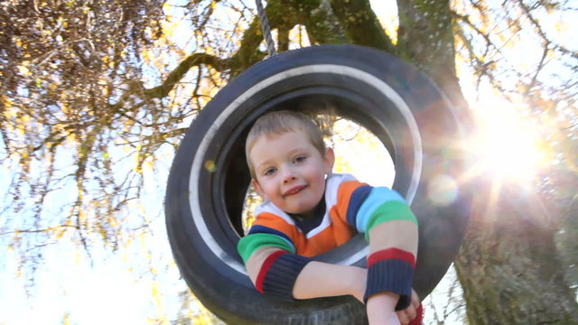 Boy in tire swing