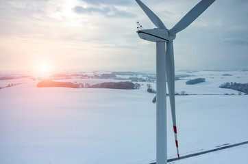 Sunset above windmill on the field in winter