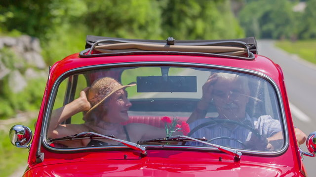 Senior couple kissing in an old zastava car