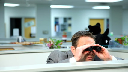 Businessman peeking over cubicle with binoculars - Powered by Adobe