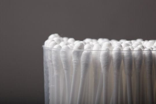 cotton buds with plastic packing on a dark background