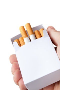 Pack of cigarettes in hand, isolated on white background