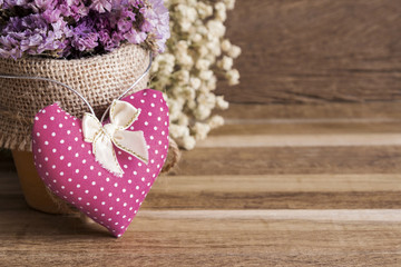Heart fabric and dry flowers on wooden background