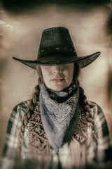 Old West Cowgirl Hat Low Wide. Old west cowgirl with hat low blocking eyes, edited in vintage film...
