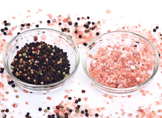 Himalayan pink salt and rainbow peppercorns on white background