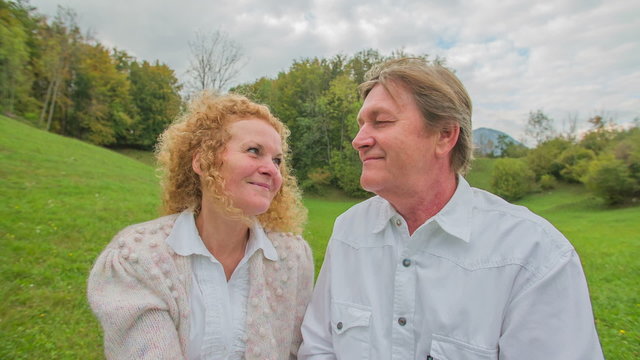 Elderly couple sitting on the bench in the contryside