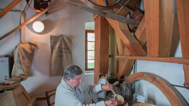 Old man working in the old water mill