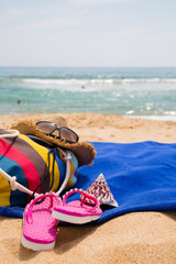 Hat, sunglasses, towel and other items on a sand  beach