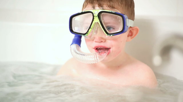 Young boy in bathtub with snorkel gear