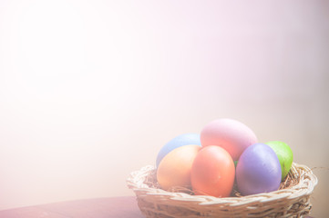 Easter eggs in basket on wooden tablw with soft background