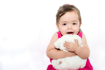Adorable little girl hugging a teddy bear