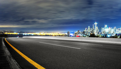 asphalt road with cityscape of seattle at night