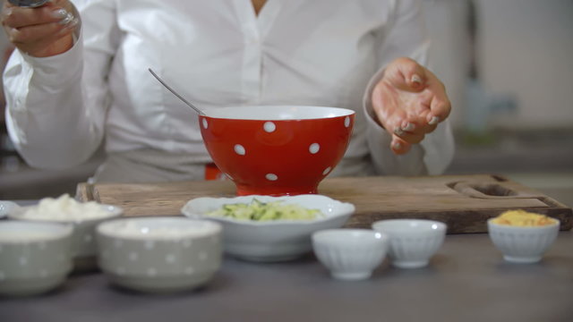 Cook putting ingredient into cup
