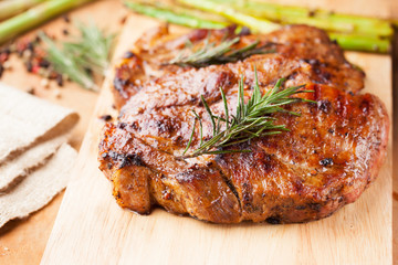 grilled pork chop with rosemary on wooden board