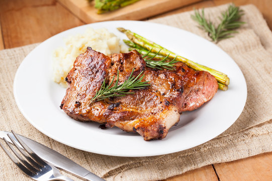 Pork Chop With Mashed Potato And Asparagus On Plate