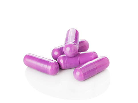 Purple pill capsules on white background