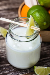 Delicious homemade organic yoghurt with lime juice  in a glass jar on wooden table