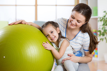 Cute kid girl  and mother with fitness ball