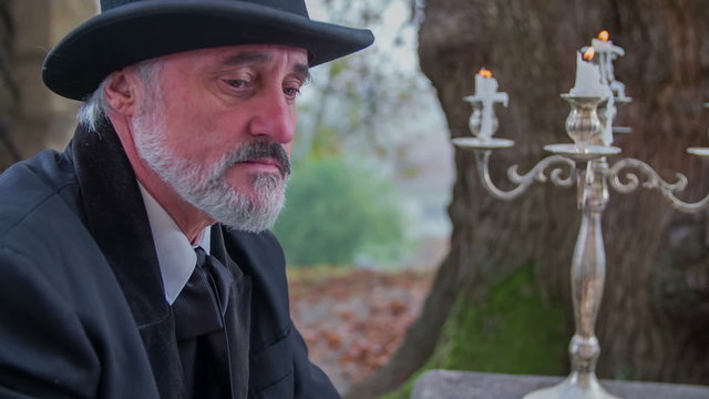 Old man thinking before starting to write 
