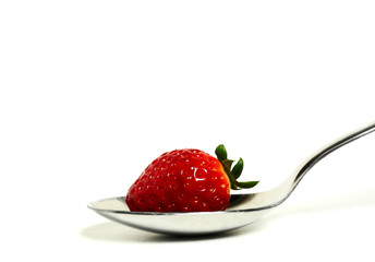 Клубника в ложке на белом фоне
