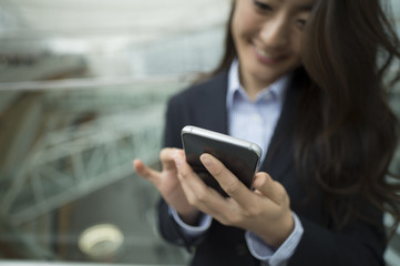 Fototapeta premium Woman who was wearing a suit looking at the smartphone