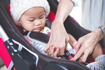 Mother securing her baby in the car seat in her car