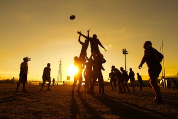 giocatori di rugby partita di sera al tramonto - obrazy, fototapety, plakaty