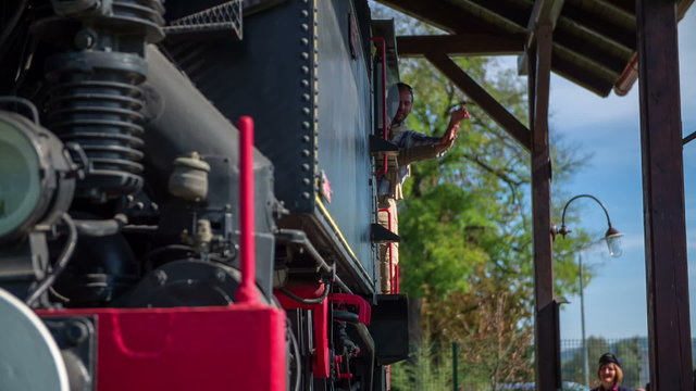 Couple waving there hands from old locomotive 