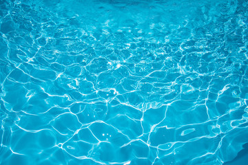 Beautiful blue water in swiiming pool with sun reflection