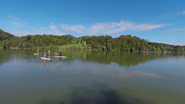Surfers paddling on the lake 