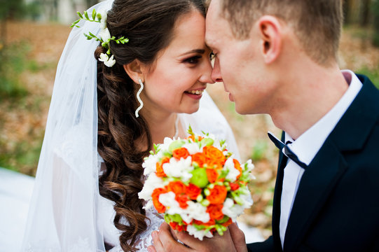 Very close up look of bride and groom with small orange wedding