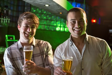 Portrait of two men having beer at bar
