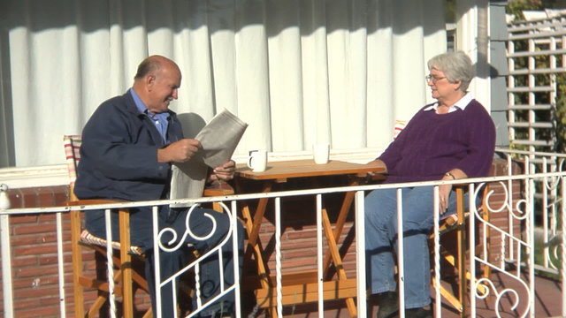 Senior couple having coffee on front porch