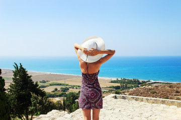 Portrait of beautiful woman wearing wide straw hat relaxing on the sea side