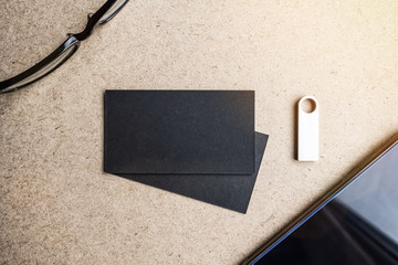 Two black business cards with flash drive, smartphone and glasses