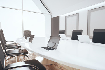 Luxury conference room with white oval table, laptops and blank