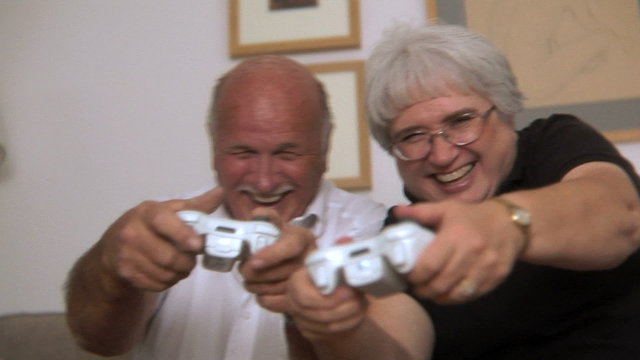 Senior couple having fun playing a video game
