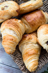 Freshly Baked French butter Pastries in the Basket. croissants, pains au chocolat, pains aux raisins. Shallow DOF, Selective Focus