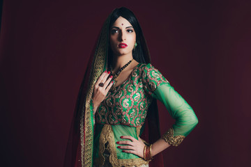 Vintage Bollywood fashion girl against dark red background.