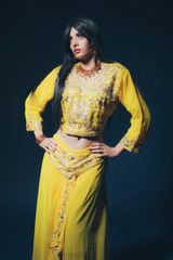 Vintage Bollywood fashion girl in yellow clothes against dark bl