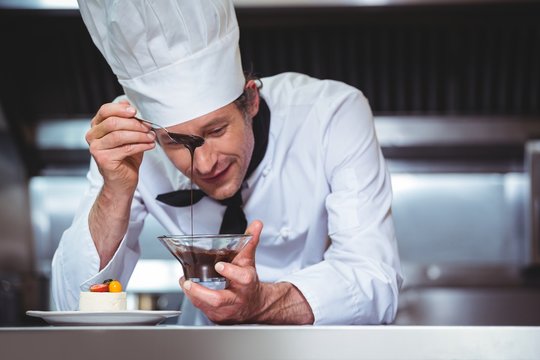 Chef Putting Chocolate Sauce On A Dessert