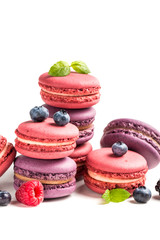 Delicious macaroons with fruits on white background