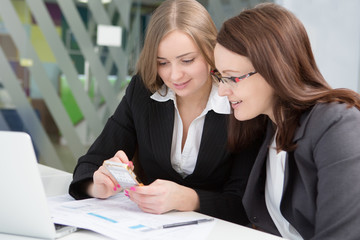 two businesswoman using smartphones
