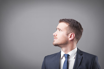 Pensive businessman on grey background