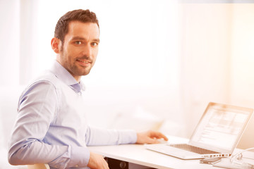 Young business man working at home on his laptop