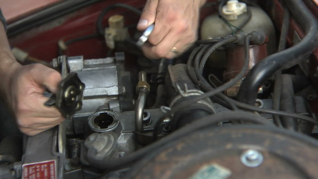 Close up of hands working on car engine