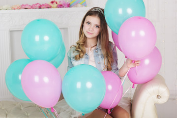Fototapeta na wymiar Pretty teen girl with many blue and pink balloons