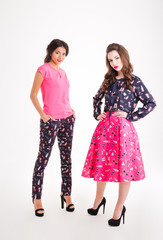 Two attractive young women standing and posing