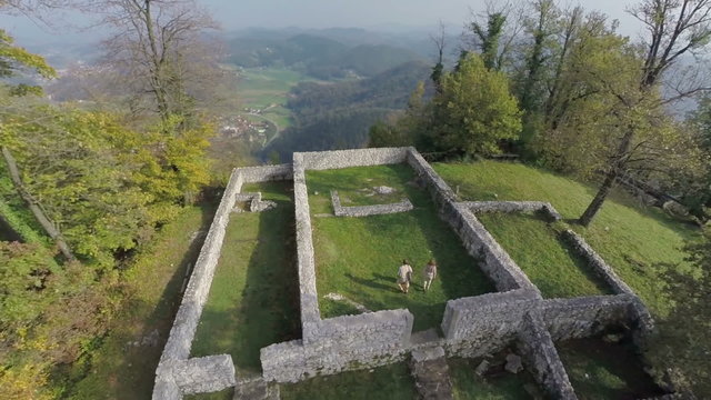 Couple walks towards the look out spot on a castle ruins 